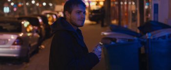 Movie still from “Simon Killer” (2012), directed by Antonio Campos – A man holding a bottle of water in his hand; Medium shot, Over the shoulder angle