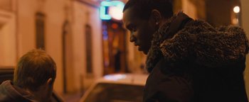 Movie still from “Simon Killer” (2012), directed by Antonio Campos – A young man standing in the street at night; Close Up shot, Over the shoulder angle