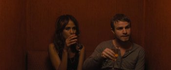Movie still from “Simon Killer” (2012), directed by Antonio Campos – A man and a woman sitting next to each other drinking wine; Medium shot, Over the shoulder angle