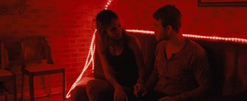 Movie still from “Simon Killer” (2012), directed by Antonio Campos – A man and a woman sitting next to each other on a couch; Medium shot, Over the shoulder angle