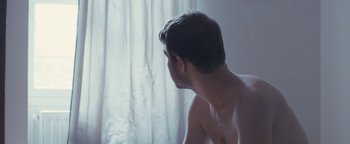 Movie still from “Simon Killer” (2012), directed by Antonio Campos – A man sitting in front of a window looking out the window; Extreme Close Up shot, High angle