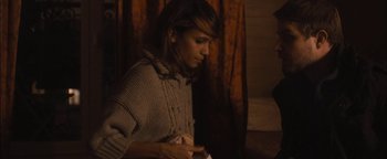 Movie still from “Simon Killer” (2012), directed by Antonio Campos – A woman in a sweater is looking down at her cell phone; Medium shot, High angle
