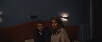 Movie still from “Simon Killer” (2012), directed by Antonio Campos – A man and a woman sitting on a couch in a room; Medium shot, Over the shoulder angle