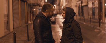 Movie still from “Simon Killer” (2012), directed by Antonio Campos – Two men standing next to each other on the sidewalk; Medium shot, Over the shoulder angle