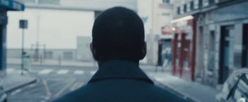 Movie still from “Simon Killer” (2012), directed by Antonio Campos – A man standing on the side of the street; Extreme Close Up shot, Over the shoulder angle