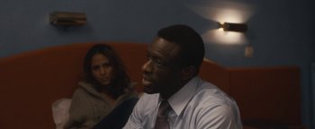 Movie still from “Simon Killer” (2012), directed by Antonio Campos – A man and a woman are sitting in a room together; Close Up shot, Over the shoulder angle