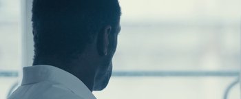 Movie still from “Simon Killer” (2012), directed by Antonio Campos – A man's face in front of a window; Extreme Close Up shot, Over the shoulder angle
