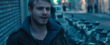 Movie still from “Simon Killer” (2012), directed by Antonio Campos – A man standing on a street at night; Close Up shot, Over the shoulder angle