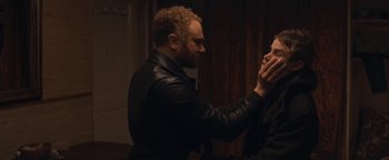 Movie still from “Simon Killer” (2012), directed by Antonio Campos – A man wearing a leather jacket touching another man's face; Close Up shot, Over the shoulder angle