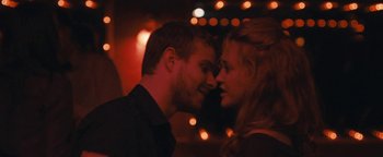 Movie still from “Simon Killer” (2012), directed by Antonio Campos – A man and a woman face to face in front of lights; Close Up shot, Over the shoulder angle