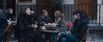 Movie still from “Simon Killer” (2012), directed by Antonio Campos – A group of people sitting at a table with food; Medium shot, Over the shoulder angle