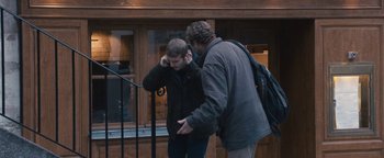 Movie still from “Simon Killer” (2012), directed by Antonio Campos – Two men standing next to each other on the street; Medium shot, Over the shoulder angle