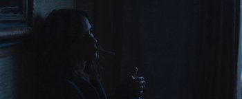 Movie still from “Simon Killer” (2012), directed by Antonio Campos – A woman is smoking a cigarette in the dark; Medium shot, Over the shoulder angle