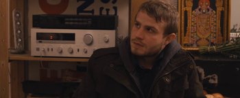 Movie still from “Simon Killer” (2012), directed by Antonio Campos – A man sitting in front of an audio equipment; Close Up shot, Over the shoulder angle