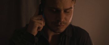 Movie still from “Simon Killer” (2012), directed by Antonio Campos – A person talking on a cell phone; Close Up shot, Over the shoulder angle