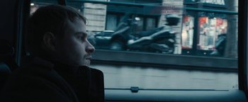 Movie still from “Simon Killer” (2012), directed by Antonio Campos – A man sitting in a car looking out the window; Close Up shot, Over the shoulder angle