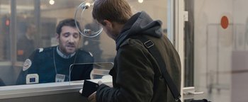 Movie still from “Simon Killer” (2012), directed by Antonio Campos – A man is looking at his cell phone in front of a store window; Medium shot, Over the shoulder angle