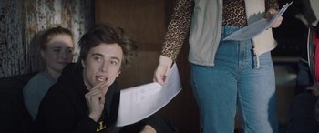 Movie still from “Slalom” (2020), directed by Charlène Favier – A person holding a piece of paper near a man; Close Up shot, Over the shoulder angle