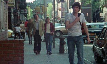 Movie still from “Smithereens” (1982), directed by Susan Seidelman – A group of people walking down a sidewalk; Wide shot, High angle