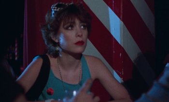 Movie still from “Smithereens” (1982), directed by Susan Seidelman – A woman sitting in front of a striped wall; Close Up shot, Over the shoulder angle