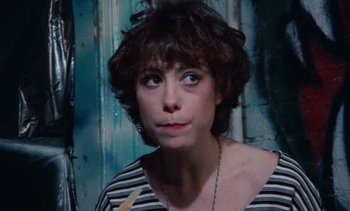 Movie still from “Smithereens” (1982), directed by Susan Seidelman – A person wearing a striped shirt; Close Up shot, Over the shoulder angle