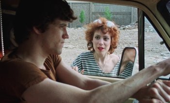 Movie still from “Smithereens” (1982), directed by Susan Seidelman – A man and a woman sitting in the back of a car looking in the mirror; Close Up shot, Over the shoulder angle