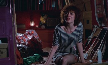 Movie still from “Smithereens” (1982), directed by Susan Seidelman – A woman sitting on the ground in a room; Medium shot, High angle