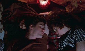 Movie still from “Smithereens” (1982), directed by Susan Seidelman – Two young people laying on the ground in a room; Medium shot, Overhead angle