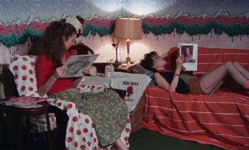 Movie still from “Smithereens” (1982), directed by Susan Seidelman – Two women sitting on a bed in a room; Wide shot, High angle