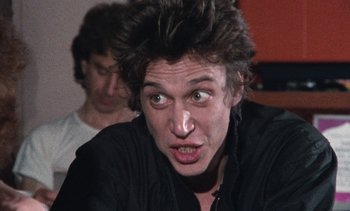 Movie still from “Smithereens” (1982), directed by Susan Seidelman – A man with a goofy look on his face; Close Up shot, Low angle