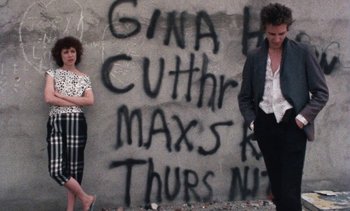 Movie still from “Smithereens” (1982), directed by Susan Seidelman – Two people standing in front of a wall with graffiti; Medium shot, Low angle
