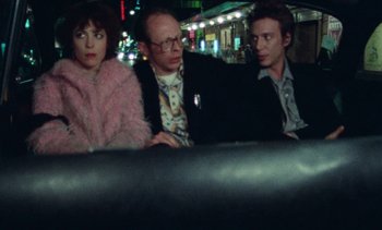 Movie still from “Smithereens” (1982), directed by Susan Seidelman – A group of people sitting next to each other on a couch; Medium shot, High angle