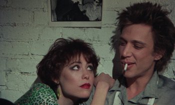 Movie still from “Smithereens” (1982), directed by Susan Seidelman – A man and a woman sitting next to each other; Close Up shot, Over the shoulder angle