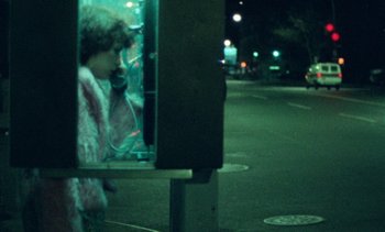 Movie still from “Smithereens” (1982), directed by Susan Seidelman – A woman in a fur coat is talking on a phone; Medium shot, High angle