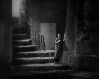 Movie still from “Street Angel” (1928), directed by Frank Borzage – An old photo of a woman standing on some stairs; Wide shot, High angle