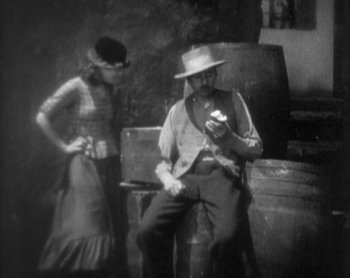 Movie still from “Street Angel” (1928), directed by Frank Borzage – An old photo of a man and a woman; Medium shot, High angle