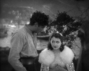 Movie still from “Street Angel” (1928), directed by Frank Borzage – A man and a woman standing next to each other in front of trees; Medium shot, High angle