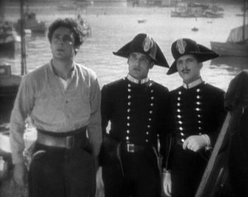 Movie still from “Street Angel” (1928), directed by Frank Borzage – A man standing next to two other men in uniform; Medium shot, High angle