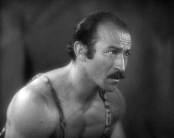 Movie still from “Street Angel” (1928), directed by Frank Borzage – An old photo of a man with a mustache looking to his left; Close Up shot, Low angle