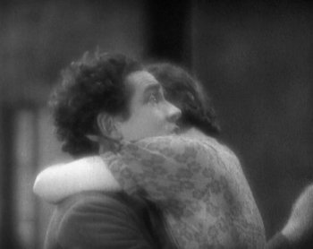 Movie still from “Street Angel” (1928), directed by Frank Borzage – A black and white photo of a man and a woman hugging; Medium shot, High angle