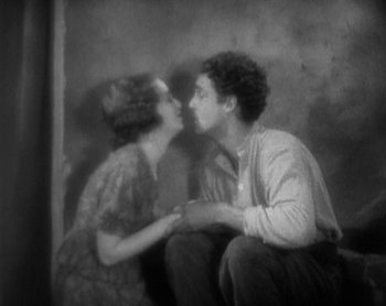 Movie still from “Street Angel” (1928), directed by Frank Borzage – A man and a woman sitting on the ground; Medium shot, High angle