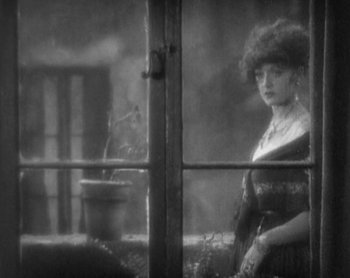Movie still from “Street Angel” (1928), directed by Frank Borzage – A woman standing in front of an open window; Medium shot, High angle