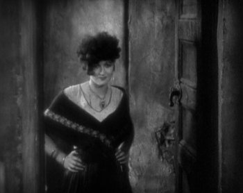 Movie still from “Street Angel” (1928), directed by Frank Borzage – An old photo of a woman standing in front of a door; Medium shot, High angle