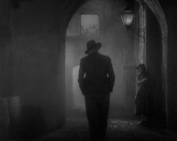 Movie still from “Street Angel” (1928), directed by Frank Borzage – A man in a hat is walking in a dark alley; Wide shot, Low angle