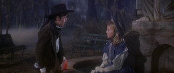 Movie still from “Summer and Smoke” (1961), directed by Peter Glenville – A man and a woman sitting on a bench in a park; Medium shot, Over the shoulder angle
