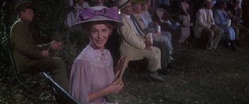 Movie still from “Summer and Smoke” (1961), directed by Peter Glenville – An older woman wearing a hat and holding a book in her hand; Medium shot, Over the shoulder angle
