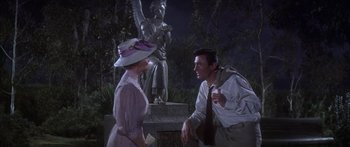 Movie still from “Summer and Smoke” (1961), directed by Peter Glenville – A man and a woman talking in front of an angel statue; Medium shot, Low angle