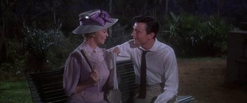 Movie still from “Summer and Smoke” (1961), directed by Peter Glenville – A man and a woman sitting next to each other on a park bench; Medium shot, Over the shoulder angle