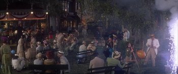 Movie still from “Summer and Smoke” (1961), directed by Peter Glenville – A group of people sitting on park benches at night; Wide shot, High angle
