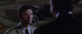 Movie still from “Summer and Smoke” (1961), directed by Peter Glenville – A man wearing a suit and tie talking to another man wearing a suit and tie; Close Up shot, Over the shoulder angle